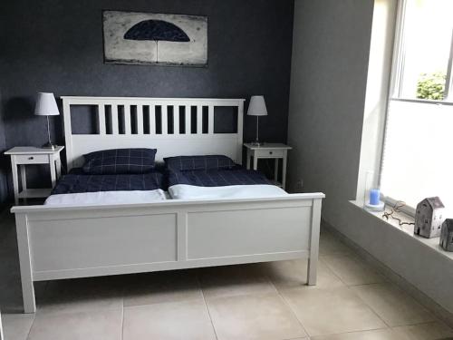1 dormitorio con cama blanca y almohadas azules en Ferienwohnung Bina, en Surwold