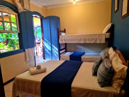 a bedroom with two beds and a window at Pousada Konquista in Paraty