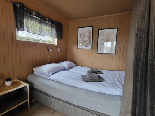 1 dormitorio con 1 cama blanca y 2 almohadas en Koselig studioleilighet i Svolvær - Lofoten ved Svolværgeita, Djevelporten en Svolvær