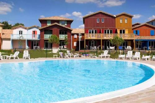 uma grande piscina em frente a algumas casas em Le Nid du Teich em Le Teich
