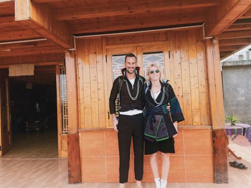 a man and a woman standing in front of a building at Lee's Charm Homestay in Sa Pa