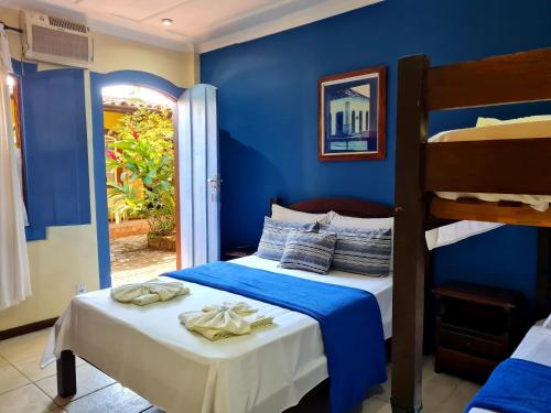 a bedroom with blue walls and two bunk beds at Pousada Konquista in Paraty