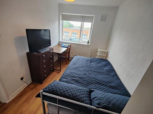 a small bedroom with a bed and a television at Beautiful and homely accommodation, Archway in Islington near Camden town in London
