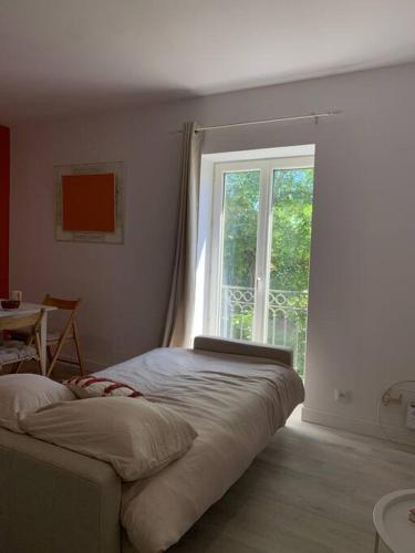 une chambre avec un lit et une grande fenêtre dans l'établissement Appartement cœur de village Numéro1, à Peyriac-de-Mer