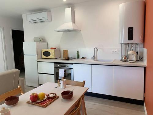 - une cuisine avec une table et une assiette de fruits dans l'établissement Appartement cœur de village Numéro1, à Peyriac-de-Mer