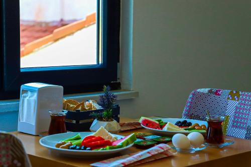 einen Tisch mit Teller mit Lebensmitteln und Eiern darauf in der Unterkunft İmroz Adali's Butik Otel in Gokceada Town