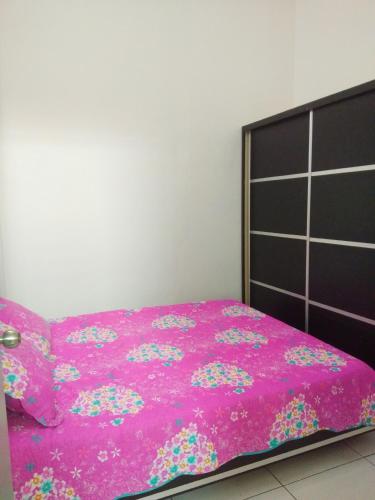 a bedroom with a pink bed with a pink blanket at Tuah Homestay Musleem Only in Chemor