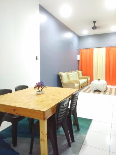 a dining room with a wooden table and chairs at Tuah Homestay Musleem Only in Chemor
