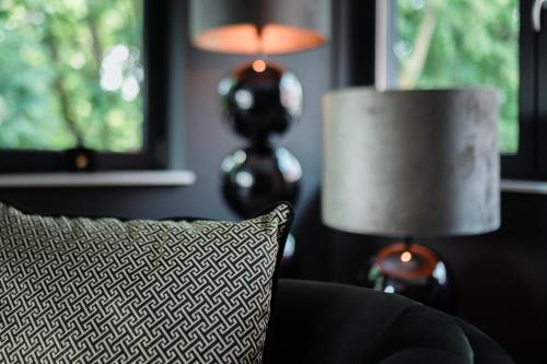 a couch with a pillow and two lamps in a room at Sellmann´s Boutique Hotel in Dortmund