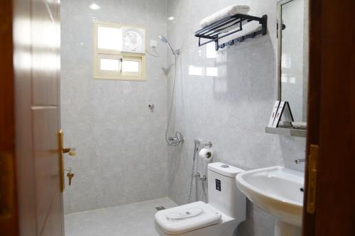 a white bathroom with a toilet and a sink at مساكن الراحة in Abha