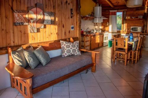 a couch in a living room with a kitchen at Piedramora in Villa Giardino