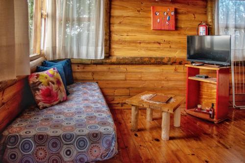 a living room with a couch and a tv and a table at Piedramora in Villa Giardino