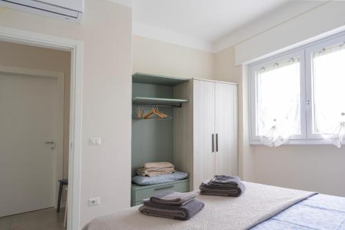a white bedroom with a bed and a window at Borgo alla Pieve Apartments by Garda Facilities in Manerba del Garda