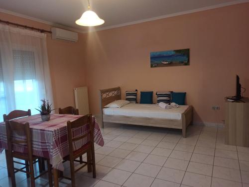 a bedroom with a bed and a table and chairs at Irene's Sunny residence in Limnos in Néa Koútali
