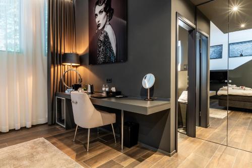 a room with a desk with a chair and a bedroom at Sellmann´s Boutique Hotel in Dortmund