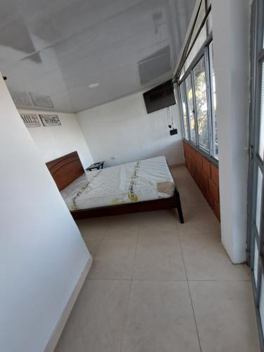 um pequeno quarto com uma cama e uma janela em Carolina Ruiz em Villamaría