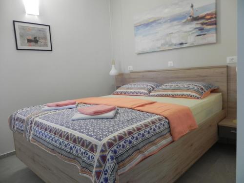 a bedroom with a bed with two pillows at Apartments Katalenić in Selce