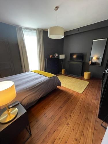 Schlafzimmer mit einem Bett und Holzboden in der Unterkunft maison 15 mins du Mans in La Suze-sur-Sarthe