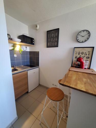 une cuisine avec une table et une horloge au mur dans l'établissement Charmant T2 Climatisé proche du centre et des commerces - Gare à 15 minutes, à Toulon
