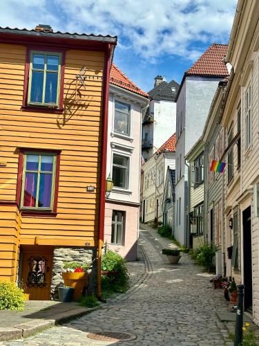 an alley in a town with buildings and a yellow house at Knøsesmauet Apartment in Bergen