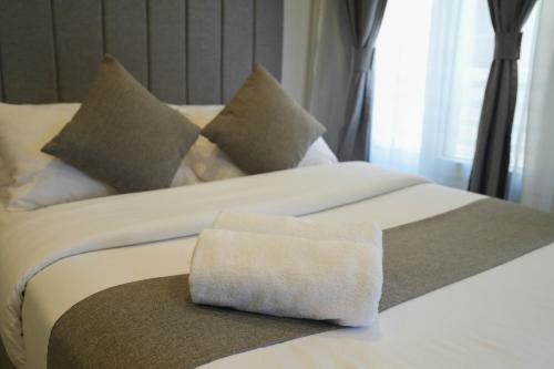 a large white bed with a towel on it at Villa 55 in 6th Of October