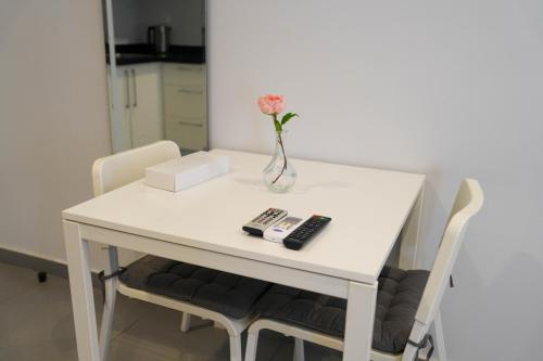 a white table with a vase with a flower in it at Villa 55 in 6th Of October