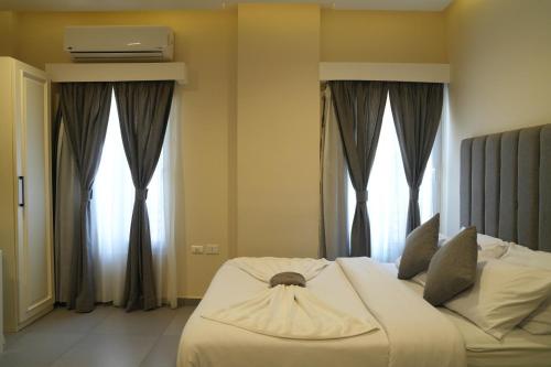 a bedroom with a large white bed with windows at Villa 55 in 6th Of October