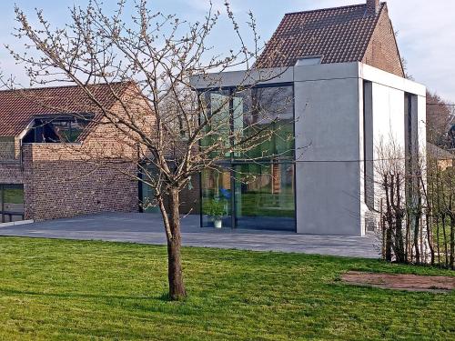a tree in a yard in front of a building at The Kettle House - Manor in Sint-Pieters-Leeuw
