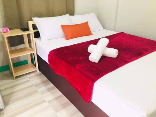 a bedroom with a bed with a red blanket at ณัฐวดี รีสอร์ท in Don Sak