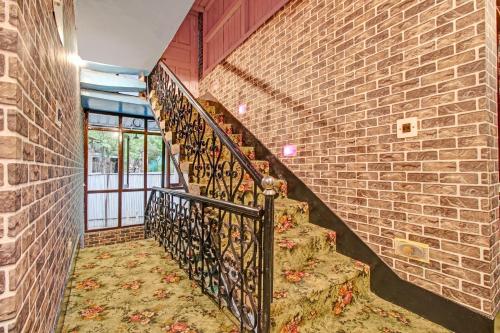 un escalier dans un bâtiment en briques avec une balustrade en fer forgé dans l'établissement Flagship Continental Guesthouse, à Nishāt