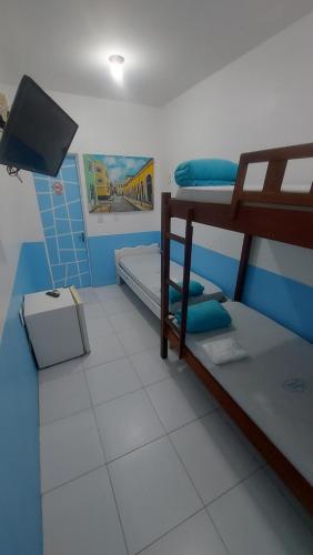 a room with two bunk beds and a flat screen tv at Hotel Pousada dos Sonhos in São Luís