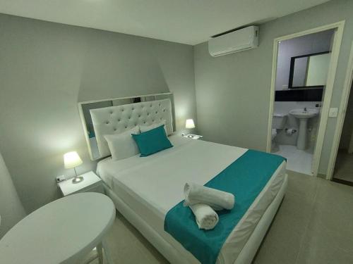 a bedroom with a large bed and a bathroom at Hotel BM-17 Cerca Al Mar Con Aire Acondicionada y Wifi in Cartagena de Indias