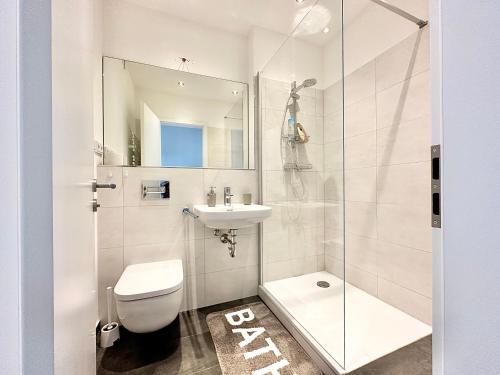 a white bathroom with a toilet and a sink at Design apartment Dresden centre - enjoy and relax in Dresden