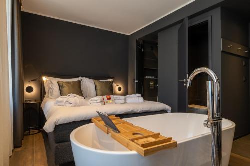 a bathroom with a bath tub and a bed at Sellmann´s Boutique Hotel in Dortmund
