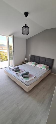 um quarto com uma cama grande e uma janela grande em Apartment sunny view em Ankaran