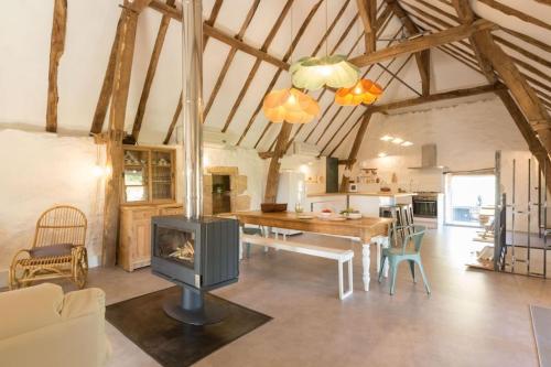 un salon avec une table et une cheminée dans l'établissement Maison Bons Jours. Grange traditionelle avec piscine, à Perpezac-le-Blanc