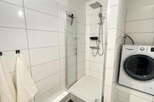 a bathroom with a washing machine and a shower at Modern City Apartment l Netflix l fast wifi l Xbox in Berlin