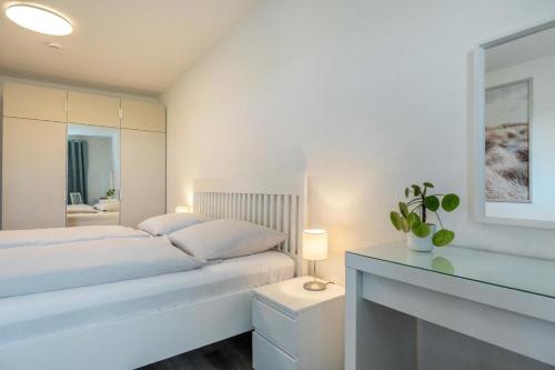 een witte slaapkamer met een bed en een open haard bij Knusthof Lafrenz - Süd in Fehmarn