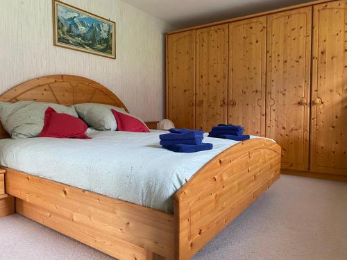 a bedroom with a wooden bed with blue towels on it at Haus Tanne Abtenau in Abtenau