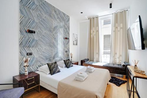 1 Schlafzimmer mit 2 Betten und einer Wand in der Unterkunft CMG Champs Elysées - Boetie 7 in Paris