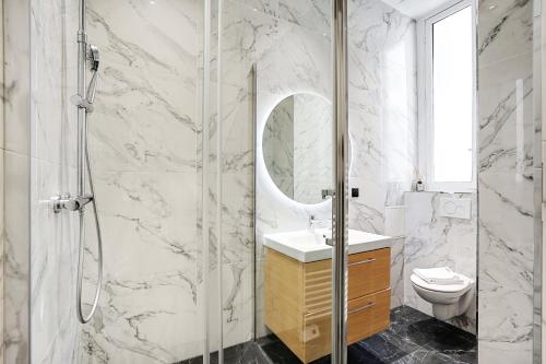 ein Bad mit einer Dusche, einem Waschbecken und einem WC in der Unterkunft CMG Champs Elysées - Boetie 7 in Paris