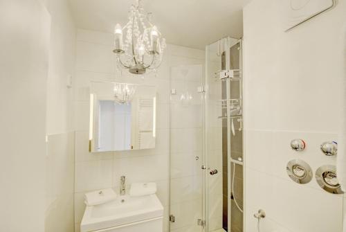a bathroom with a chandelier and a sink and a shower at fewo1846 - Fjordview - komfortables Studioapartment mit Balkon und Meerblick in Glücksburg