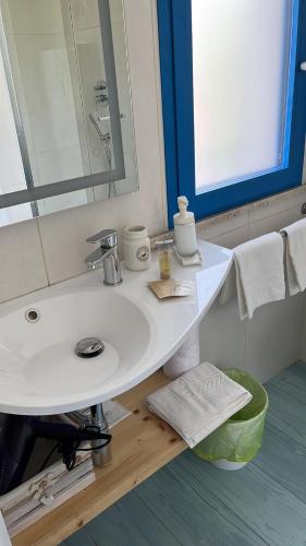 a bathroom with a white sink and a mirror at TENUTA TAURIANUM PanoramicHouse e PanoramicB&B in Palmi