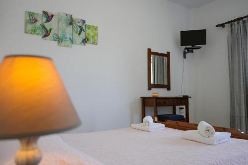 a bedroom with a bed with towels on it at Green Parrot Apartments in Frátsia