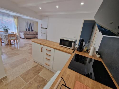 une cuisine avec un comptoir avec une cuisinière et un four dans l'établissement Maison a 200m de la plage, à Saint-Cyr-sur-Mer