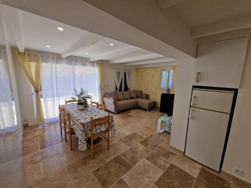 cocina y sala de estar con mesa y nevera en Appartement aux pieds des plages avec terrasse, en Saint-Cyr-sur-Mer