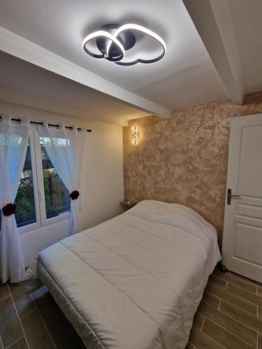 1 dormitorio con 1 cama y ventilador de techo en Appartement aux pieds des plages avec terrasse, en Saint-Cyr-sur-Mer
