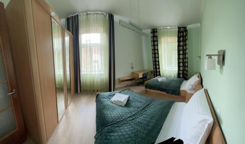 a bedroom with a green bed and a mirror at Sara’s Apartment in Mariánské Lázně