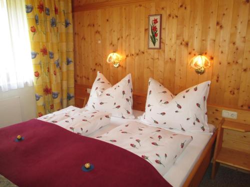 - une chambre avec un lit et des oreillers blancs dans l'établissement Appartement Hasenauer, à Hollersbach im Pinzgau
