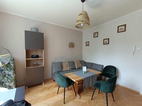 a living room with a table and chairs and a couch at Apartament Baltica Nawigator in Gdynia